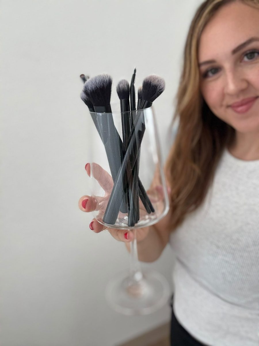 Christina hält ein Glas mit ihren Make-up-Pinseln